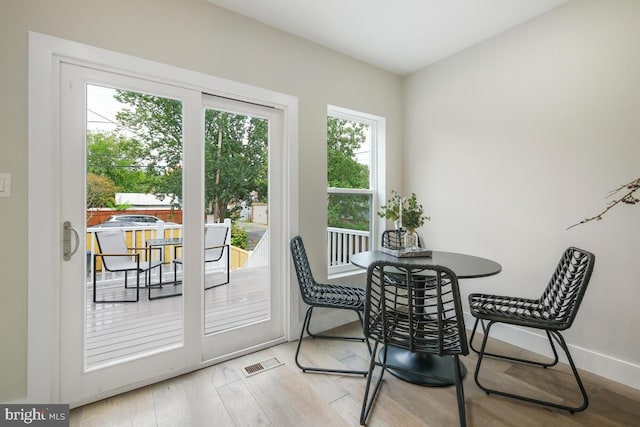 dining space with light hardwood / wood-style flooring and a healthy amount of sunlight