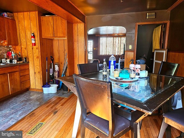 dining room with hardwood / wood-style floors and wooden walls