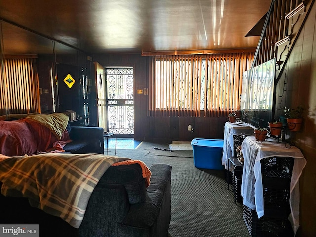 carpeted living room with wood walls