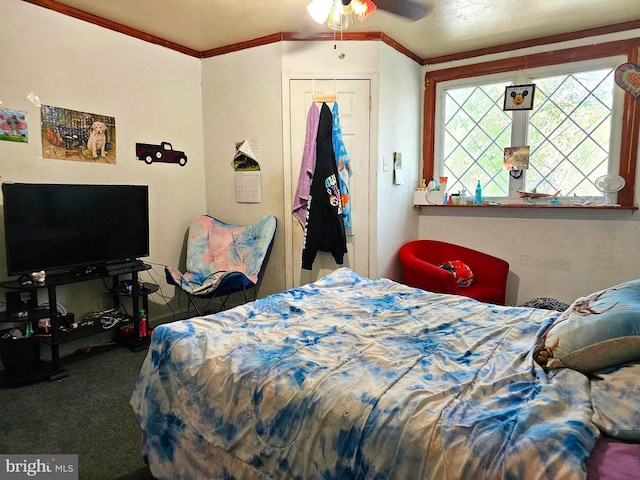 carpeted bedroom with ornamental molding, ceiling fan, and a closet