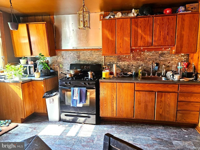 kitchen with black gas range, backsplash, sink, and hanging light fixtures