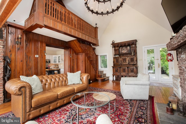 living room with high vaulted ceiling, hardwood / wood-style flooring, and wooden walls