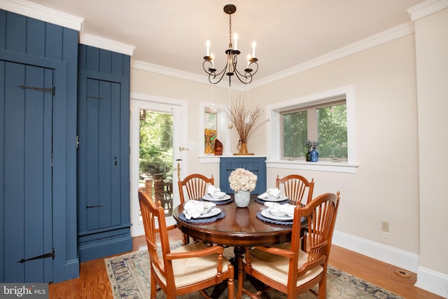 dining room featuring wood-type flooring, an inviting chandelier, and ornamental molding