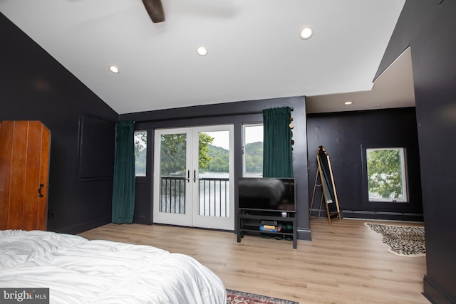 bedroom featuring light hardwood / wood-style flooring, french doors, access to exterior, ceiling fan, and vaulted ceiling