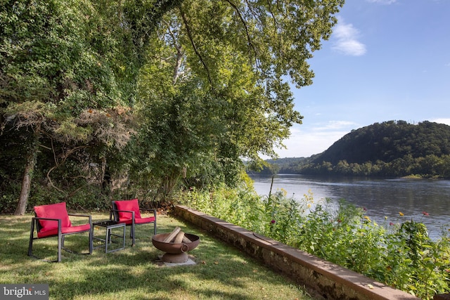 view of yard with a water view and a fire pit