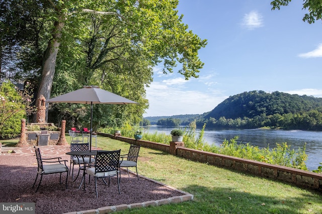 view of yard with a water and mountain view and a patio