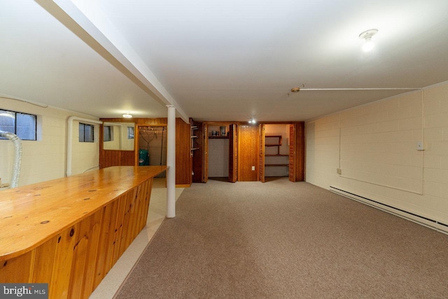 basement featuring baseboard heating, bar, and carpet