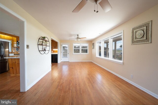 unfurnished living room featuring ceiling fan and light hardwood / wood-style floors