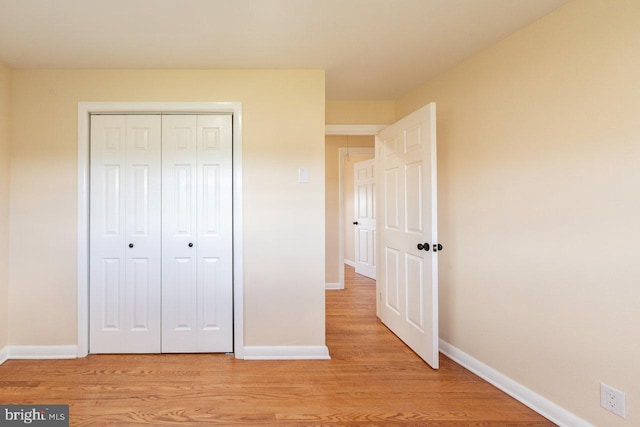 unfurnished bedroom featuring light wood-type flooring and a closet