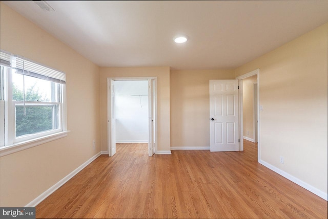 unfurnished bedroom featuring light hardwood / wood-style flooring and a closet