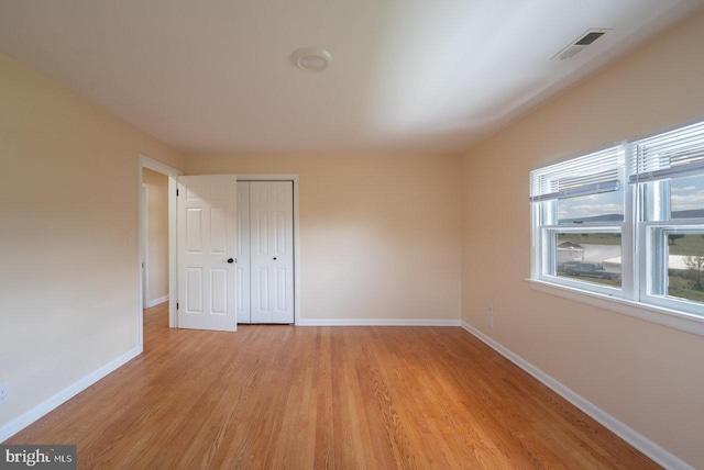 unfurnished bedroom featuring a closet and light hardwood / wood-style flooring