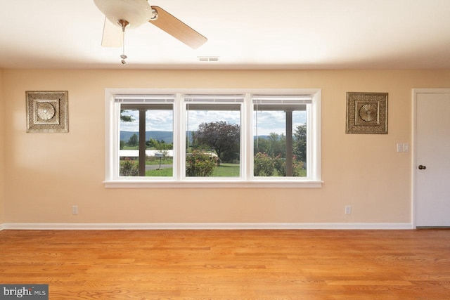 unfurnished room featuring plenty of natural light, ceiling fan, and light hardwood / wood-style floors