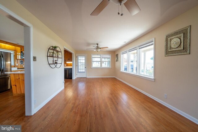 unfurnished living room featuring ceiling fan and hardwood / wood-style flooring