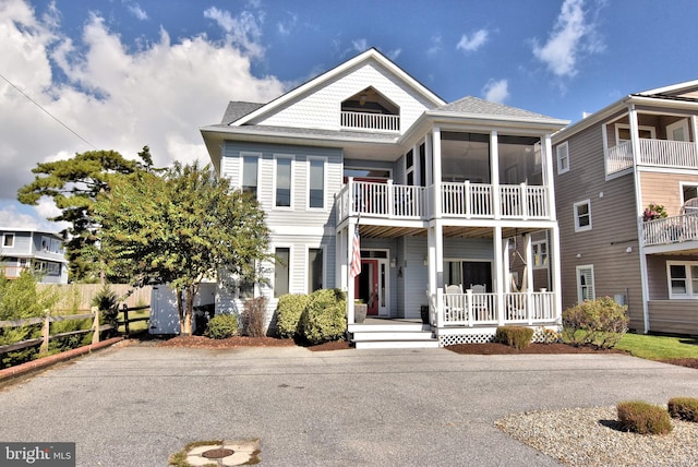 view of front of home featuring a porch, roof with shingles, and fence