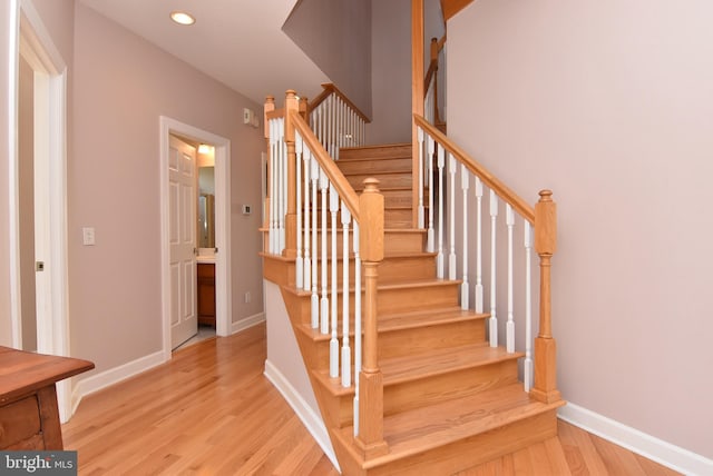 staircase with recessed lighting, baseboards, and wood finished floors