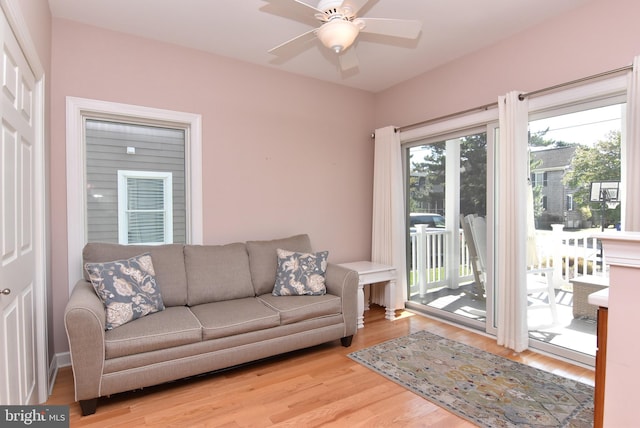 living room with light wood-type flooring and ceiling fan