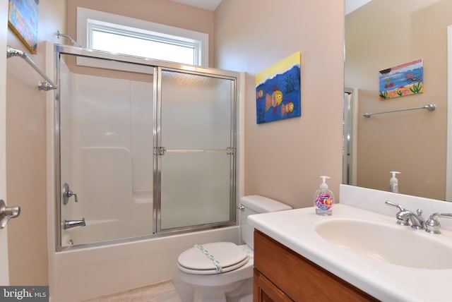 bathroom with shower / bath combination with glass door, vanity, and toilet