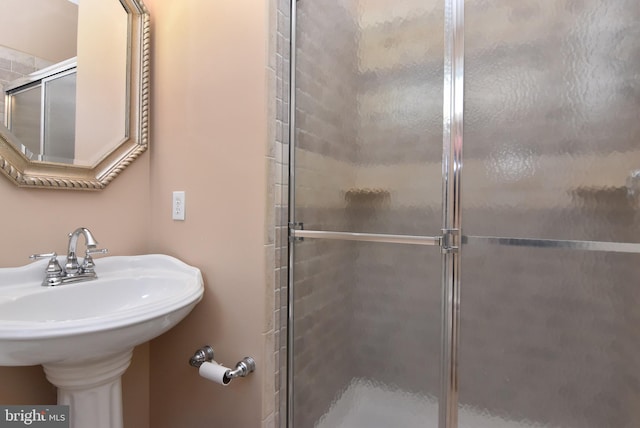 bathroom featuring a sink and a shower stall