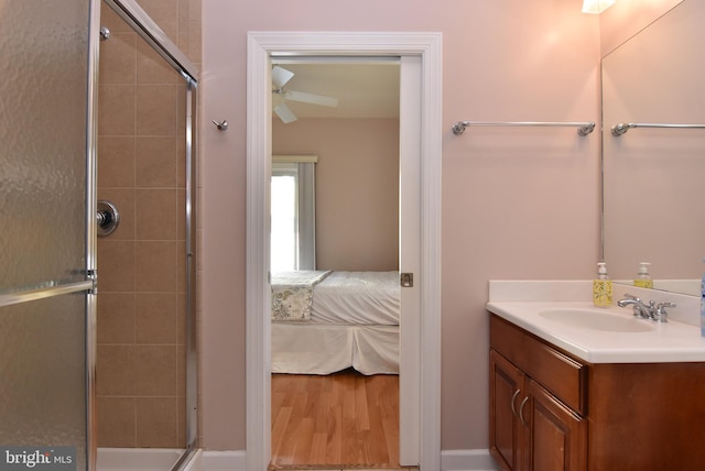 bathroom featuring ceiling fan, an enclosed shower, hardwood / wood-style flooring, and vanity