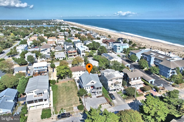 drone / aerial view with a water view, a residential view, and a beach view