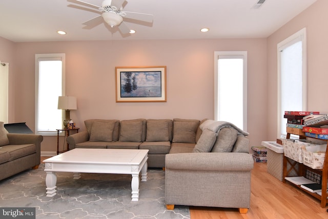 living room featuring light wood-type flooring, a ceiling fan, and recessed lighting