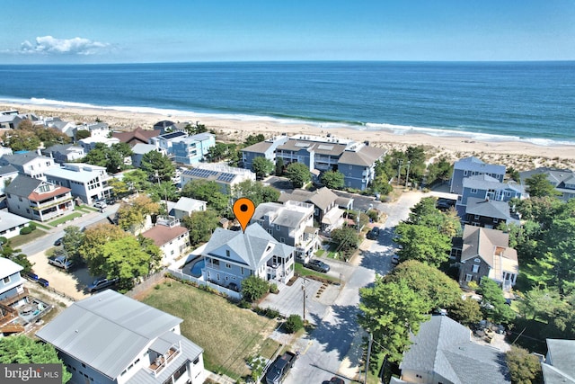 drone / aerial view featuring a beach view, a residential view, and a water view