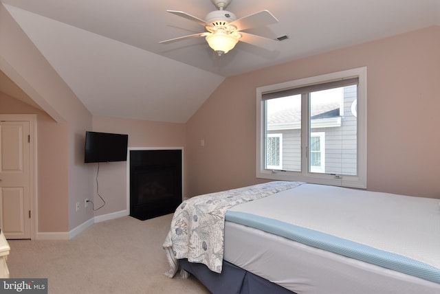 bedroom featuring lofted ceiling, light colored carpet, visible vents, a ceiling fan, and baseboards