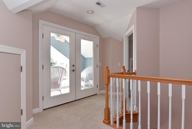 doorway to outside with light colored carpet, vaulted ceiling, and french doors