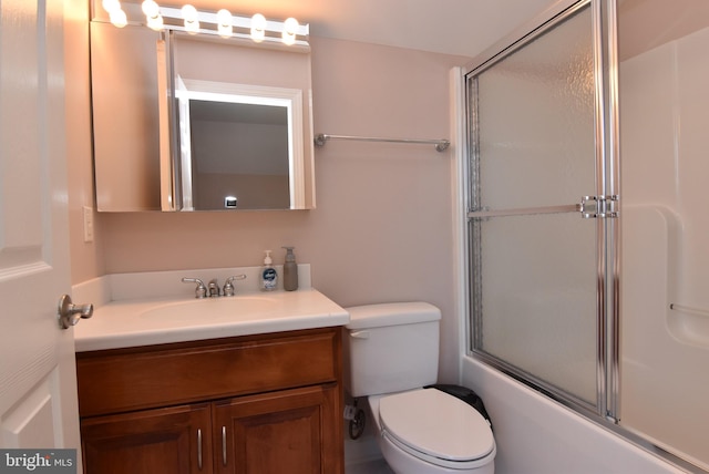 full bath with toilet, bath / shower combo with glass door, and vanity