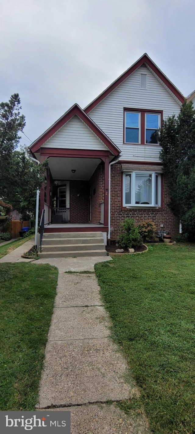 view of front facade with covered porch and a front yard