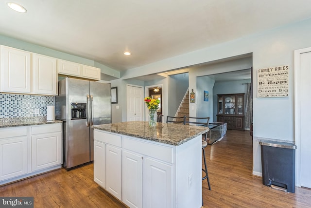 kitchen with white cabinetry, a center island, dark hardwood / wood-style floors, and stainless steel fridge with ice dispenser