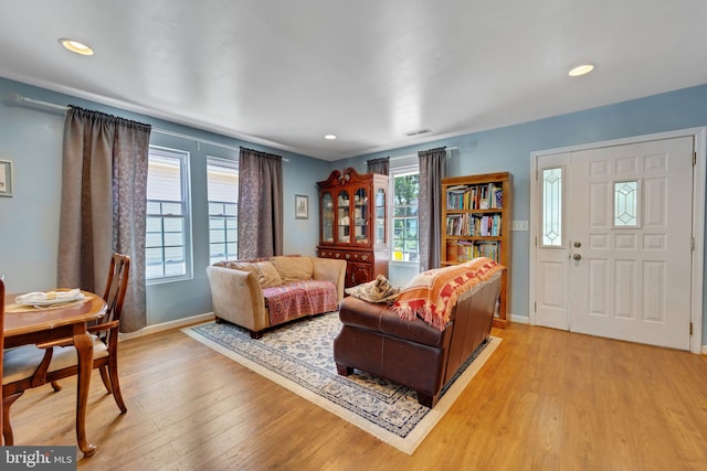 living area featuring recessed lighting, visible vents, baseboards, and light wood-style flooring