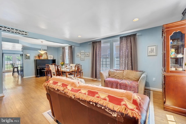 living room featuring recessed lighting, baseboards, and light wood-style floors