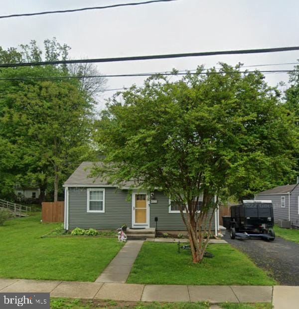 view of front of property with a front yard and central AC unit