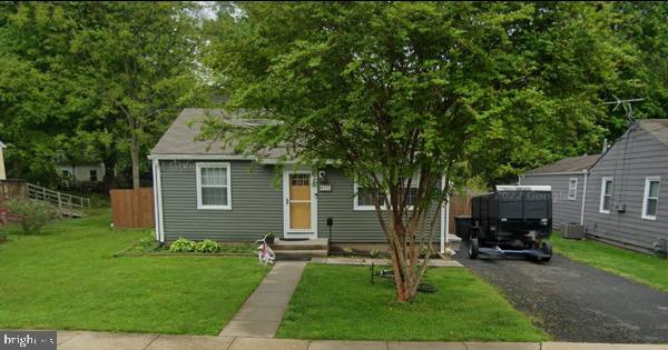 bungalow-style house featuring a front lawn and central AC unit