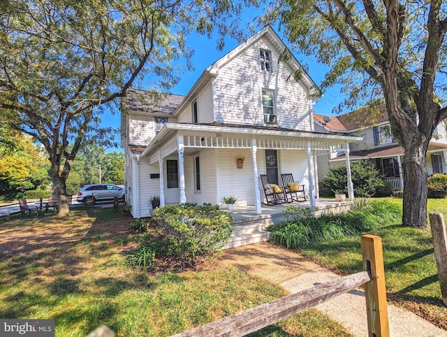 view of front facade featuring covered porch and a front yard