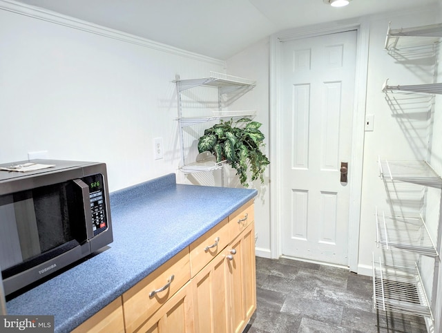 kitchen with light brown cabinetry and ornamental molding