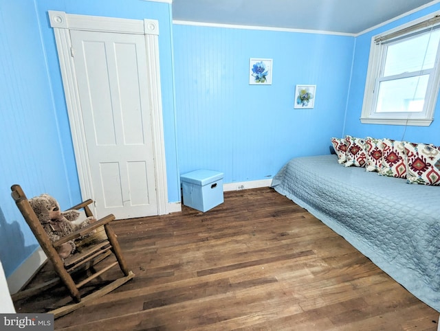 bedroom with crown molding and dark hardwood / wood-style floors