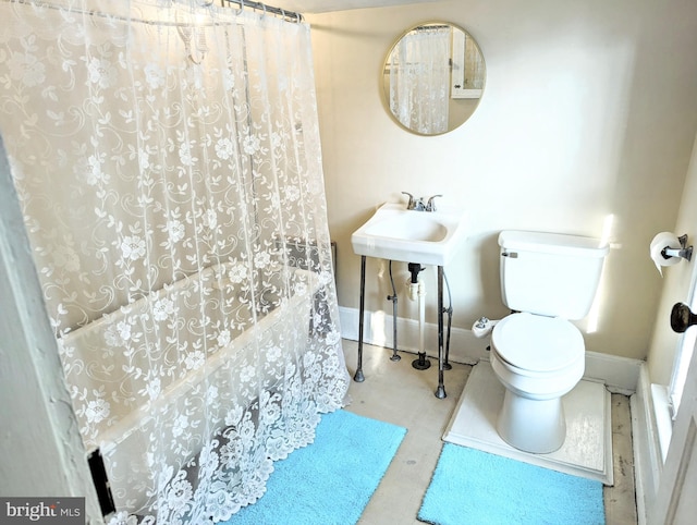 bathroom with shower / bath combination with curtain and toilet