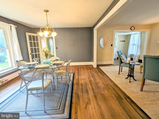 dining space with wood-type flooring and a chandelier