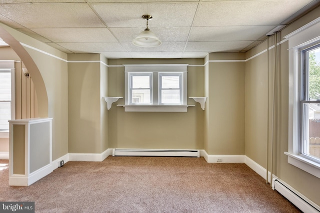 interior space with arched walkways, carpet floors, a baseboard radiator, and a paneled ceiling