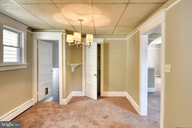 unfurnished dining area with a chandelier, a drop ceiling, light carpet, baseboards, and baseboard heating