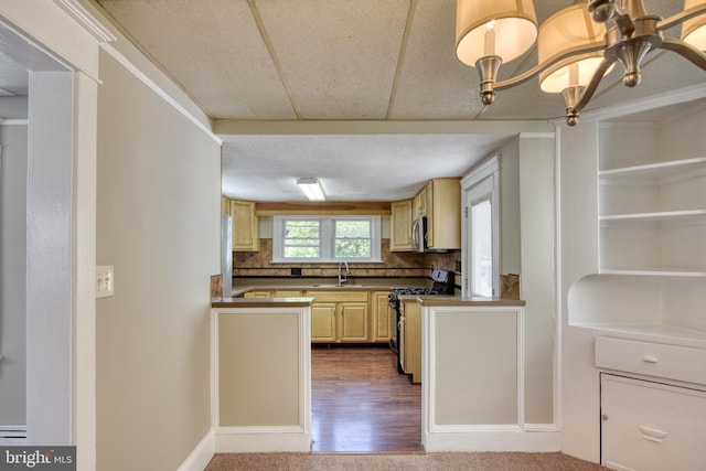 kitchen with baseboards, a sink, stainless steel appliances, light brown cabinetry, and backsplash