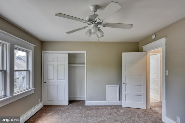 unfurnished bedroom with carpet, a closet, a baseboard radiator, and baseboards