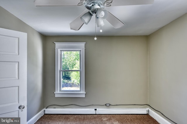 spare room with a baseboard heating unit, carpet, baseboards, and a ceiling fan