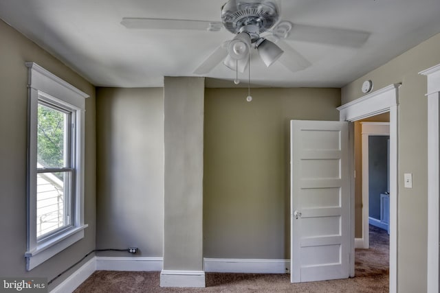 unfurnished room with ceiling fan, carpet floors, plenty of natural light, and baseboards