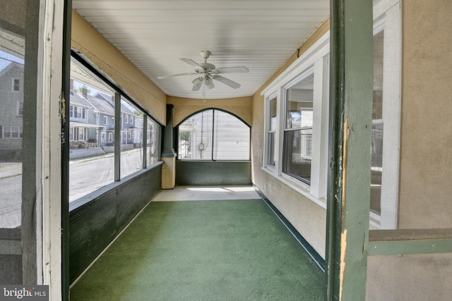 unfurnished sunroom featuring ceiling fan