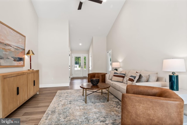 living room featuring high vaulted ceiling, ceiling fan, and wood-type flooring