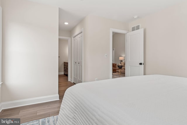 bedroom with wood-type flooring and a closet