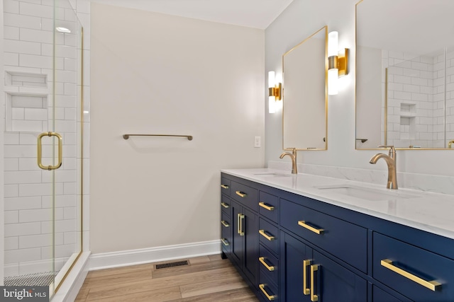 bathroom featuring vanity, wood-type flooring, and walk in shower